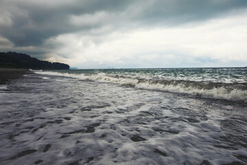 Seascape with a pebble beach and the spreading waves of the Black Sea.