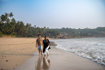 Grandmother and grandson running along the seashore on a sunny day. Love and tenderness. Active rest at the resort.