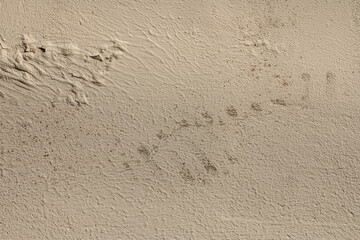 abstract background of old dirty beige embossed plastered wall painted light ocher close up