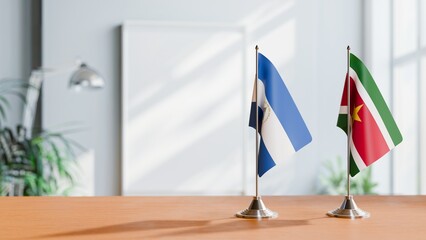 FLAGS OF NICARAGUA AND SURINAME ON TABLE