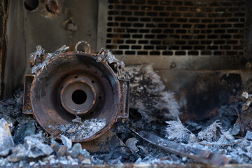 Burnt out car engine in Ukraine after a fire or accident scene, covered with rust.