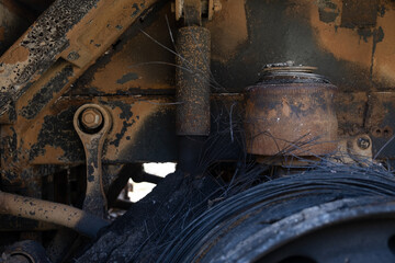 Burnt out car engine in Ukraine after a fire or accident scene, covered with rust..