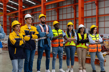 A group of mechanical engineers from different cultures and ethnicities stand with arm crossed express confidence that they are ready to do their project in a iron steel factory, Group dynamic