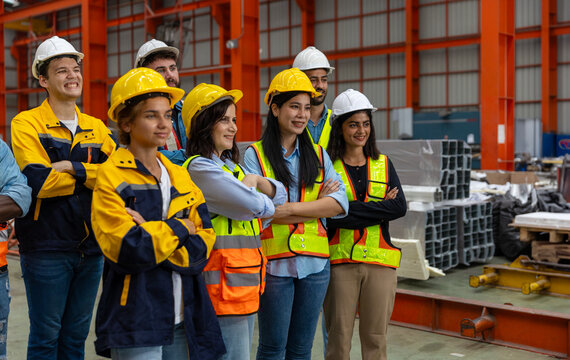 A group of mechanical engineers from different cultures and ethnicities stand with arm crossed express confidence that they are ready to do their project in a iron steel factory, Group dynamic