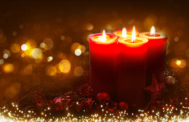 Four burning Advent candles isolated on blurred bokeh background.
