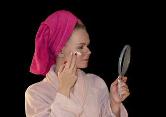 Focused Girl Applying Face Cream in Front of a Hand Mirror – Skincare and Beauty Routine