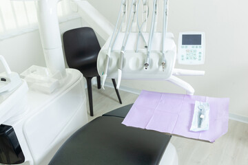 Modern dental clinic showing instruments hanging above patient chair
