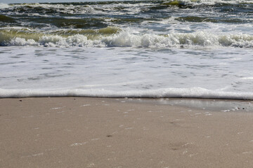 Gentle Ocean Waves Washing Over Sandy Beach. A serene close-up view of gentle ocean waves foaming as they reach the sandy shore, capturing the beauty of nature's simplicity and tranquility.