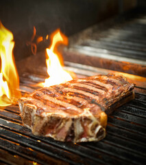 Primer plano de un filete de ternera a la parrilla en una parrilla de barbacoa con llamas