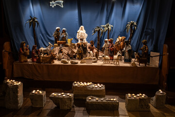 Jesus Christ nativity scene inside church in Europe during Advent. Puppet figurines, candlelights,...