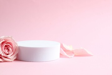 Pink rose petals with podium on a color background