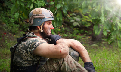 Lone sad soldier sitting in the forest