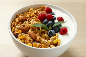 Delicious granola with berries and yogurt on a light background