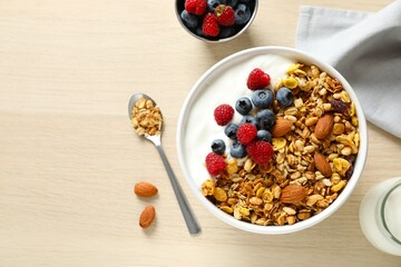 Delicious granola with berries and yogurt on a light background