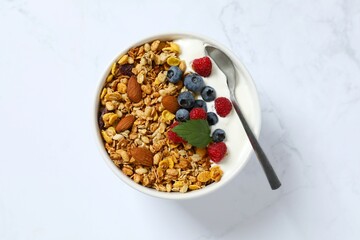 Delicious granola with berries and yogurt on a light background
