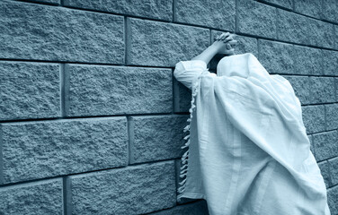 Young woman pray at the wall
