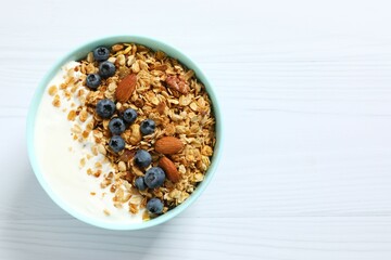 Delicious granola with berries and yogurt on a light background