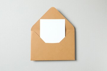 Top view photo with paper card and envelope on gray background with empty space