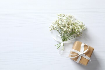 Top view photo with gypsophila flowers and gift box on white background 