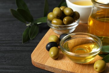 Bowl of fresh olive oil and olives with leaves on white background