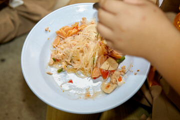 People eating spicy Vermicelli salad with minced pork in plate