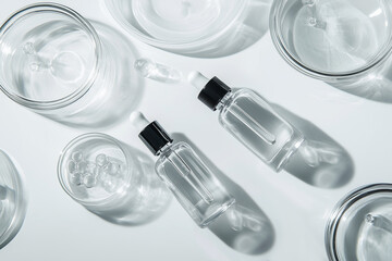 3d render with top view of transparent glass bottles with pipette for skincare, perfume or essential oils for spa. Minimalistic background for cosmetics presentation or exhibition concept