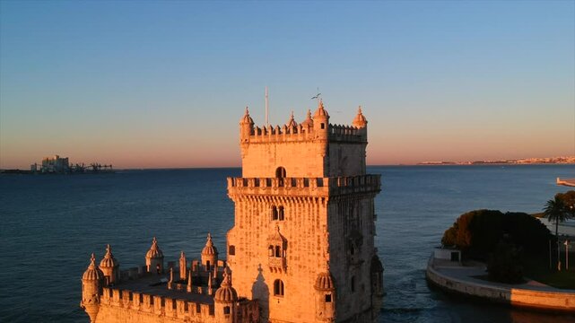 Sunrise over Lisbon's historic castle with the orange hues lighting up the coastal Belem tower
