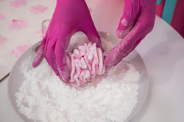 Pink marshmallow in powdered sugar. Confectioner