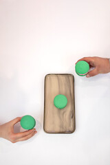 Green macaroons. Sweets. Pink filling for macaroons. Delicious pastries. Hands take macaroons