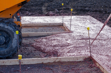 Construction site with freshly poured concrete and heavy machinery preparing for building work