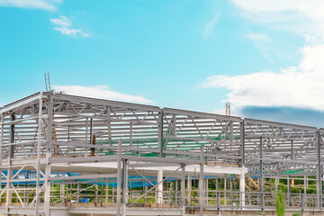 Construction of a modern steel framework under a vibrant blue sky during daylight hours