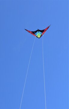 cometa multicolor volando al viento bajo un cielo azul despejado nitido luminoso