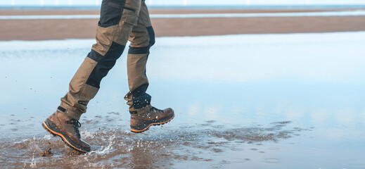 Enjoying a coastal stroll at low tide while splashing in the water on a sunny day