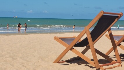 Cadeira de praia na praia e ao fundo um mar verde