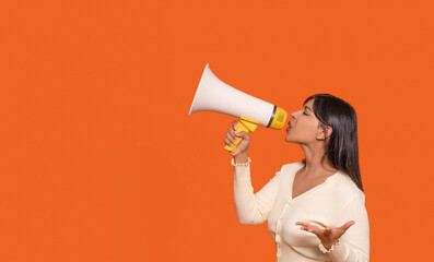 Woman using megaphone to communicate with vibrant orange background