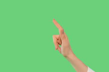 Hand gesture pointing upwards against a bright green background showing direction and intention clearly