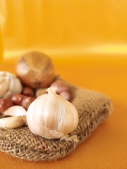 shallots, garlic, and onions, on an orange background