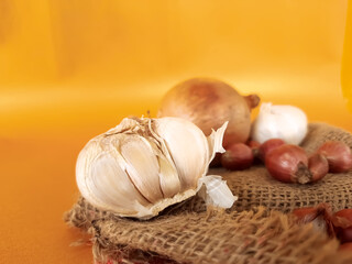 shallots, garlic, and onions, on an orange background
