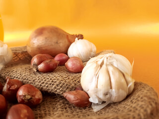 shallots, garlic, and onions, on an orange background