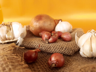shallots, garlic, and onions, on an orange background