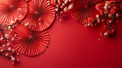 A red background with red and white paper fans and red flowers