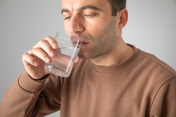 Caucasian man showing glass of water.