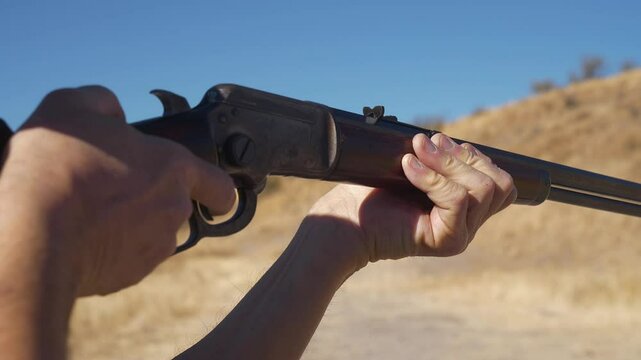 A man shooting a vintage lever action rifle