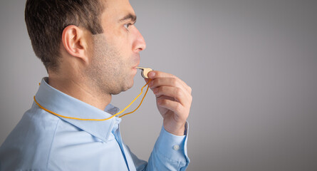 Referee or trainer holding a metal whistle.