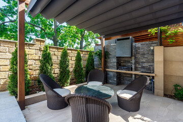 Backyard outdoor bbq zone with pergola, fireplace and hanging chair. Summer party place