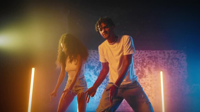 Pair of African American dancers dancing on dance floor in studio, portrait shot. People bodies synced to tempo of music, exuding vitality and energy, slow motion shot, passion and hobby of youth