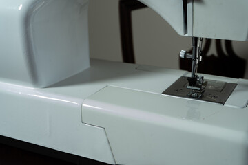 Detail of the needle, foot and presser foot of a household sewing machine.