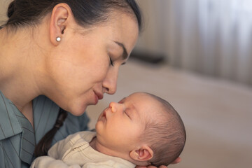 Mother kissing baby daughter. Newborn baby.