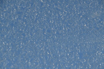 This window glass is frozen in sunny early winter day. 