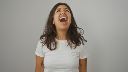 Young woman screaming looking upwards with a frustrated expression in an isolated white background